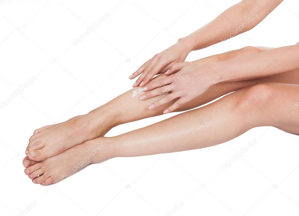 Woman Applying Cream To Her Legs