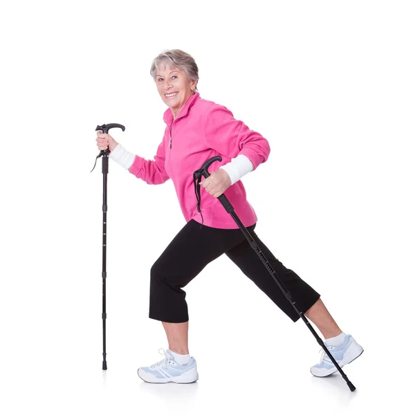 Senior vrouw lopen met stokken wandelen — Stockfoto