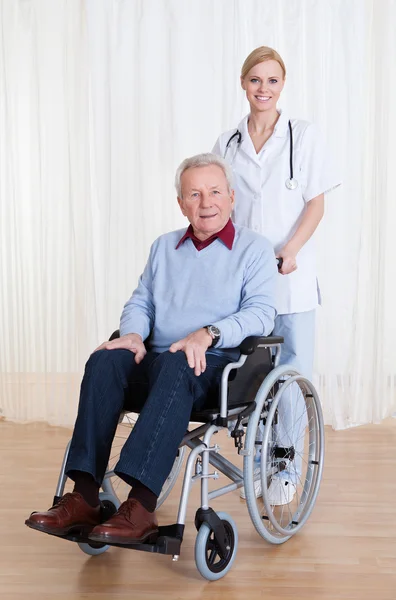 Fürsorglicher Arzt hilft behinderten Patienten — Stockfoto