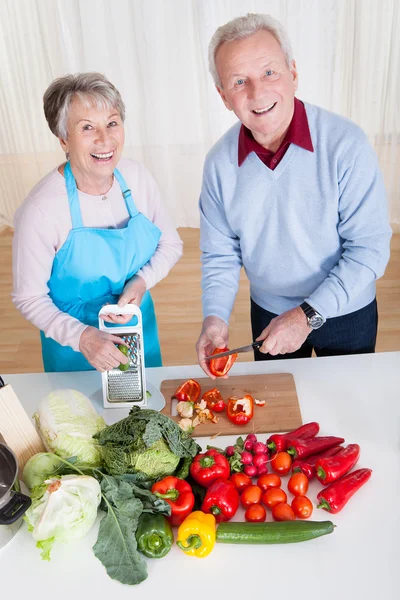 Casal sênior corte de legumes — Fotografia de Stock