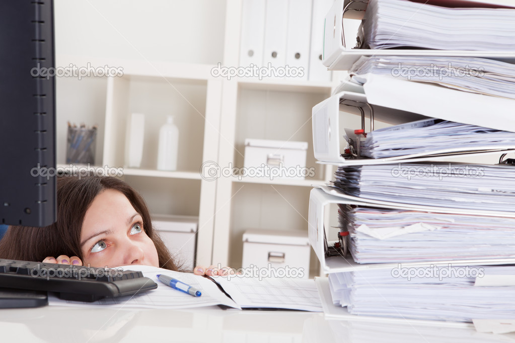 Businesswoman Looking At Stack Of Folders
