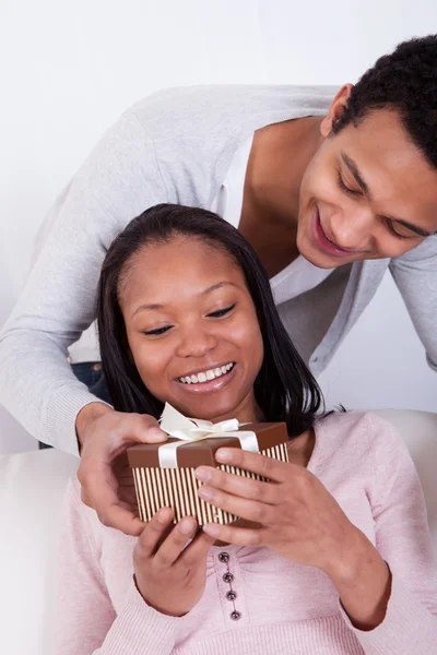 Jonge man verrassende vrouw met doos van de gift — Stockfoto