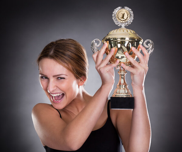 Young Woman Lifting Trophy