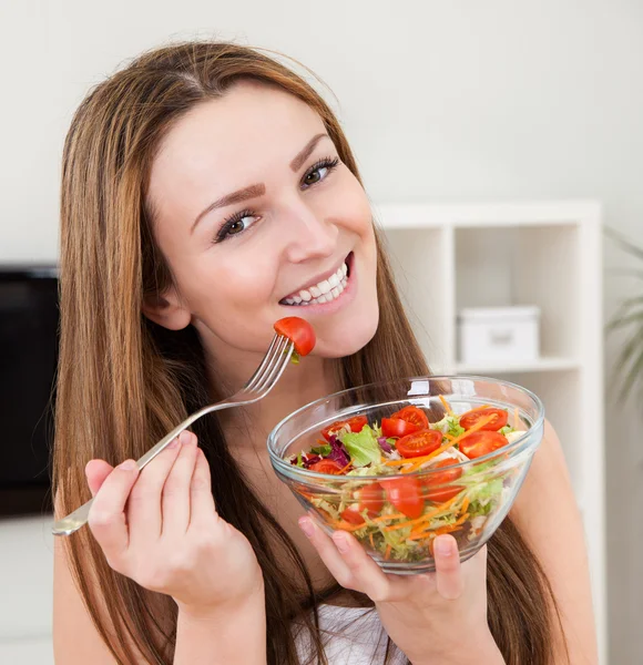 Jovem mulher comendo salada — Fotografia de Stock