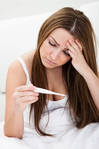 Preoccupato giovane donna controllando il suo corpo temperatura — Foto Stock