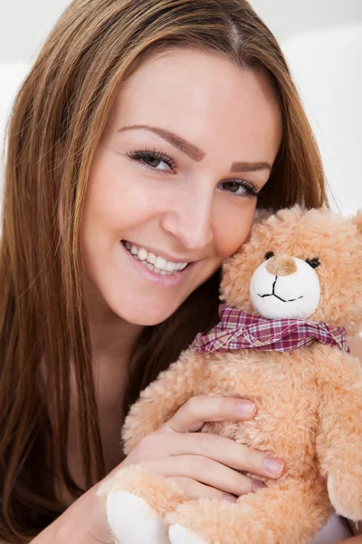 Mujer joven durmiendo con oso de peluche —  Fotos de Stock