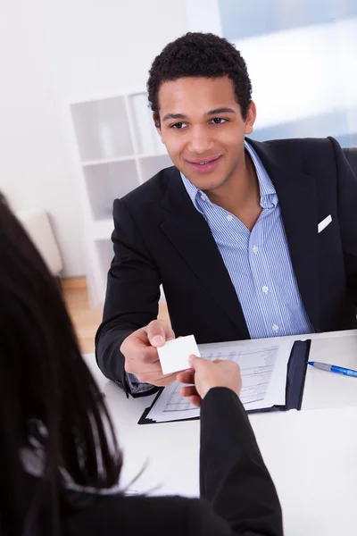 Businesswoman Offering Visiting Card To Man In Office — Stock Photo, Image