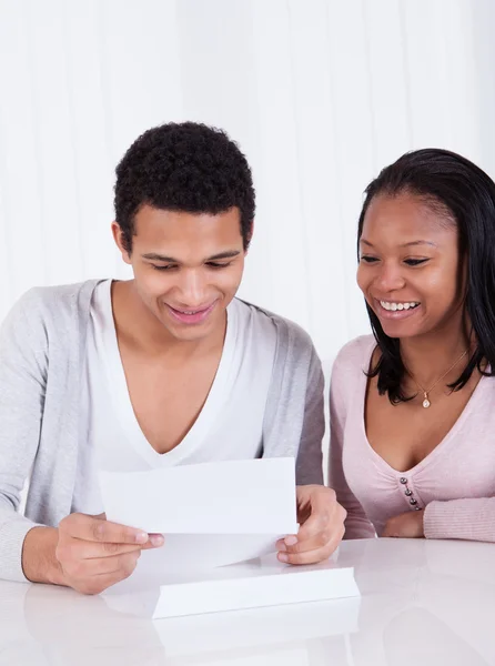 Casal feliz olhando para papel — Fotografia de Stock