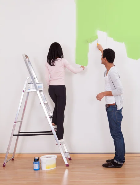 Casal pintando a parede — Fotografia de Stock