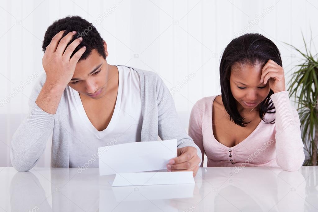 Worried Couple Looking At Paper