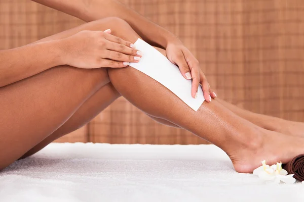 Jovem mulher fazendo depilação nas pernas — Fotografia de Stock