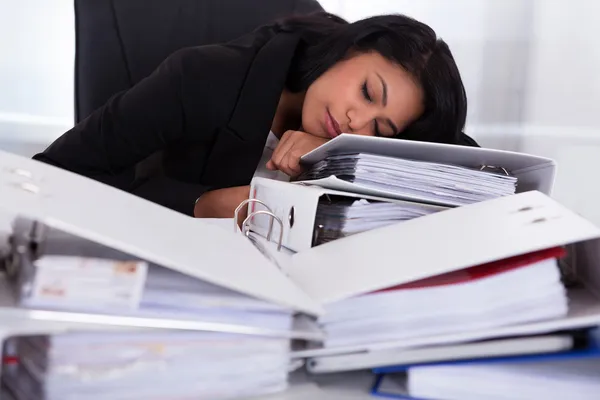 Empresaria durmiendo en montones de carpetas — Foto de Stock