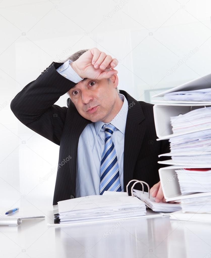 Exhausted Mature Businessman At Work