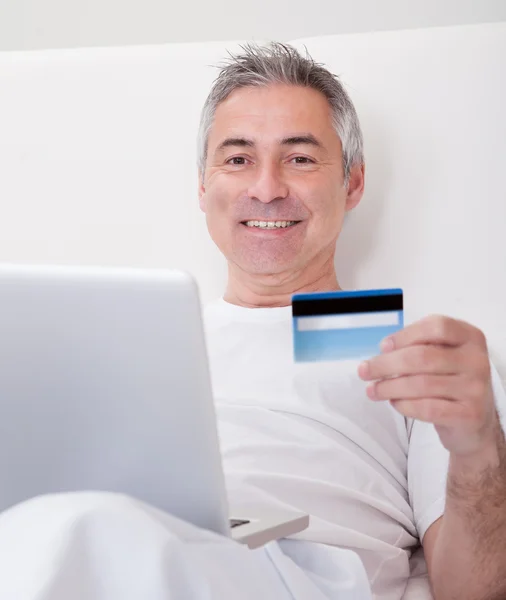 Человек зрелого возраста совершает покупки в Интернете — стоковое фото