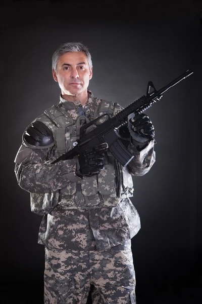 Retrato de un soldado maduro sosteniendo pistola —  Fotos de Stock