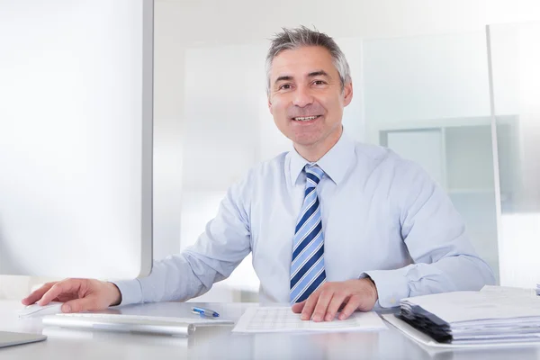 Mature Businessman Working At Desk Royalty Free Stock Images