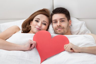 Genç sevgili çift yatakta yatarken portresi