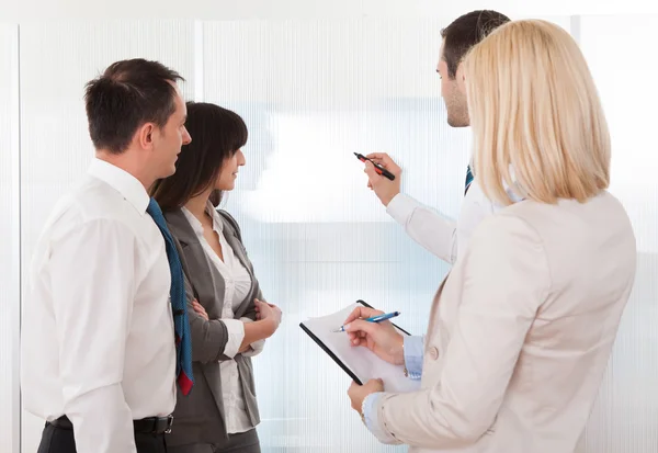 Geschäftsmann schreibt auf Whiteboard — Stockfoto