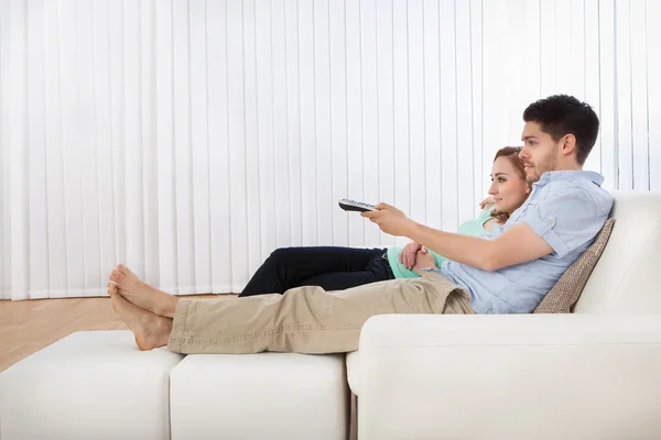 Jovem casal assistindo televisão — Fotografia de Stock