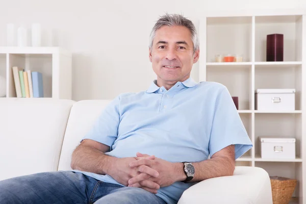 Reifer Mann sitzt auf Sofa — Stockfoto