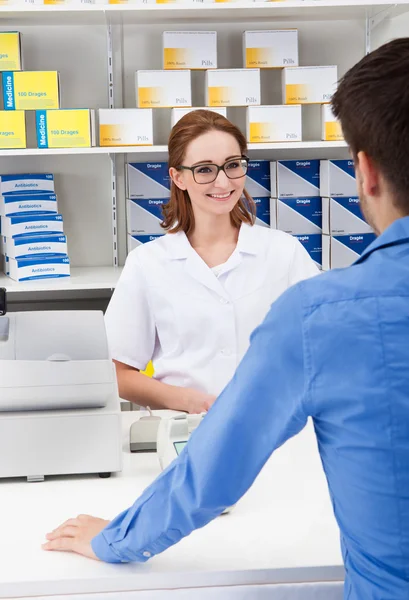 Farmacéutica femenina en farmacia con un cliente — Foto de Stock