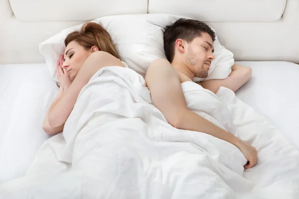 Pareja joven durmiendo en la cama — Foto de Stock