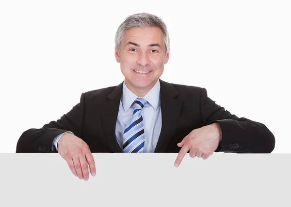 Mature Businessman Pointing At Placard Stock Image