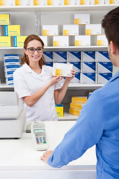 Šťastný lékárník zobrazeno lék na klienta — Stock fotografie