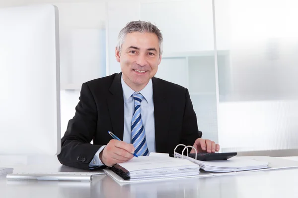 Reifer Geschäftsmann am Arbeitsplatz — Stockfoto