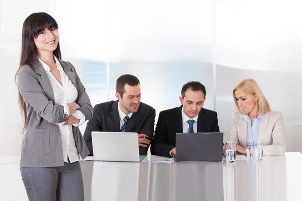 Frau steht vor Kollegen, die im Büro arbeiten — Stockfoto