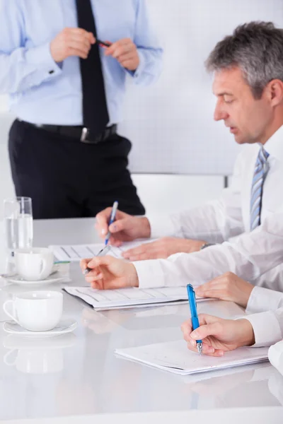 Empresarios escribiendo notas en la reunión — Foto de Stock