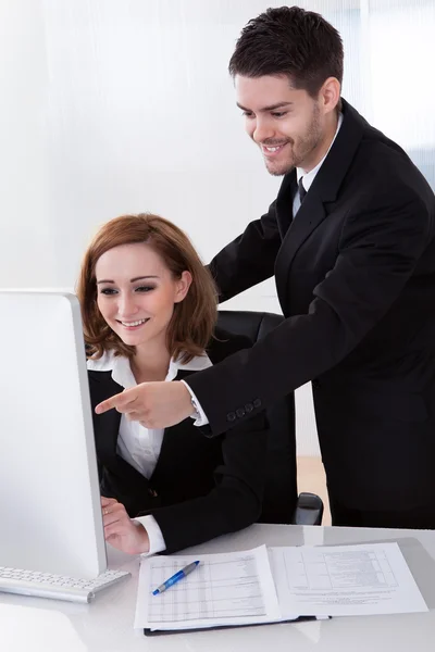 Dois parceiros de negócios felizes olhando para o computador — Fotografia de Stock