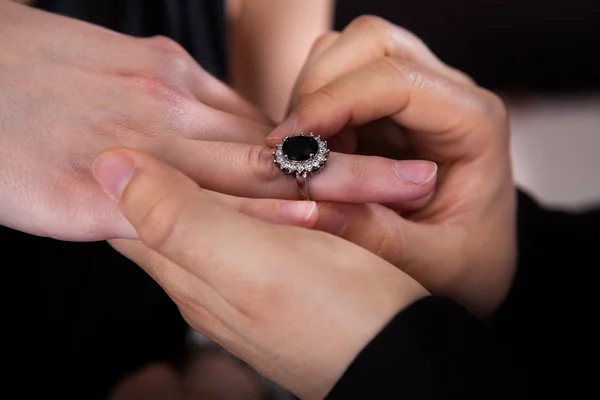 Man inserting ring in womans finger — Stock Photo, Image