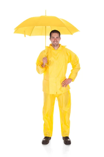 Maturo uomo indossa impermeabile e tenendo ombrello su sfondo bianco — Foto Stock