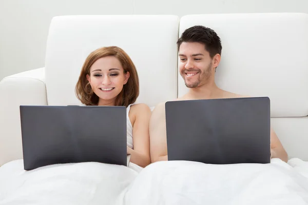 Jovem casal usando laptop — Fotografia de Stock