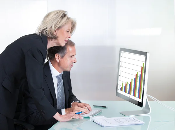 Mature Businessman And Businesswoman Looking At Graph — Stock Photo, Image