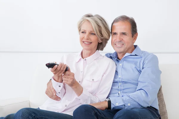 Volwassen paar kijken televisie — Stockfoto
