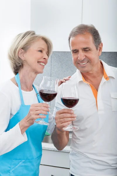 Gelukkig volwassen drinken wijn in keuken — Stockfoto