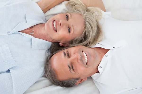 Pareja feliz acostada en la cama — Foto de Stock