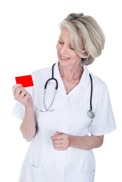Femme mûre médecin tenant carte de visite — Photo