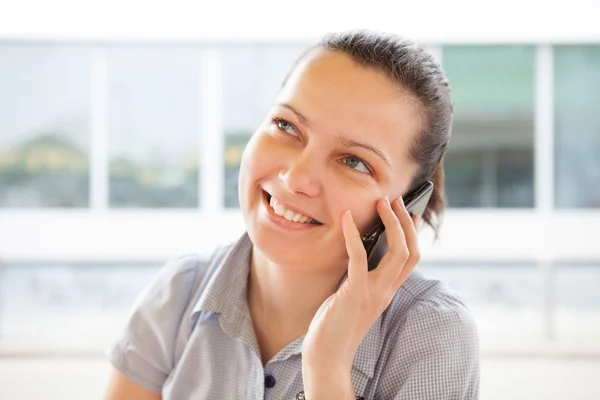 Porträt einer jungen glücklichen Frau, die mit dem Handy spricht — Stockfoto