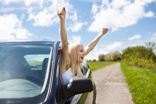 Mujer levantando la mano de la ventana del coche — Foto de Stock