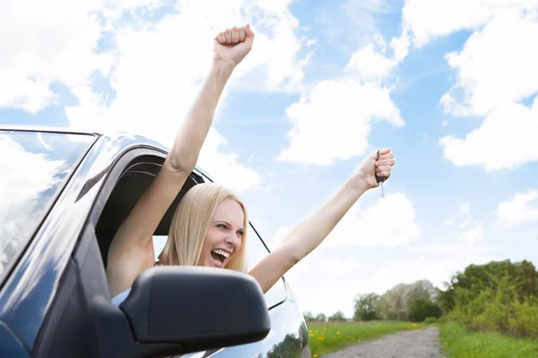 Mujer levantando la mano de la ventana del coche — Foto de Stock