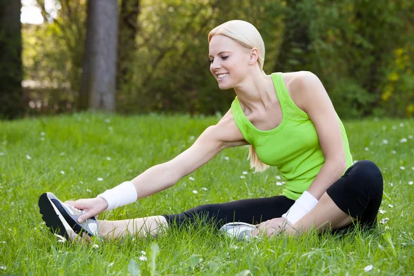 Giovane felice bionda donna stretching gamba — Foto Stock