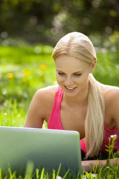 Mujer joven usando el ordenador portátil — Foto de Stock