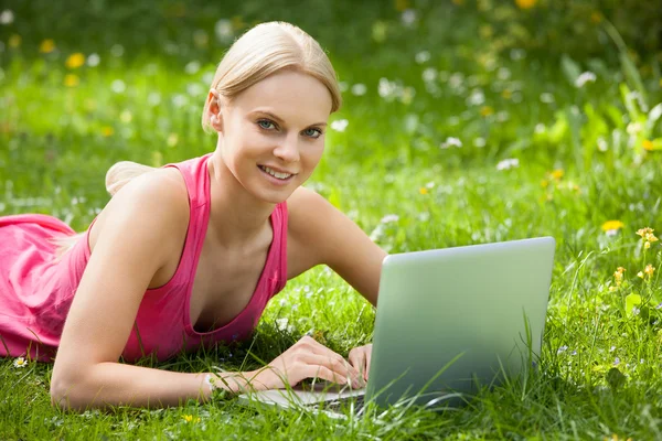 Mujer joven usando el ordenador portátil — Foto de Stock