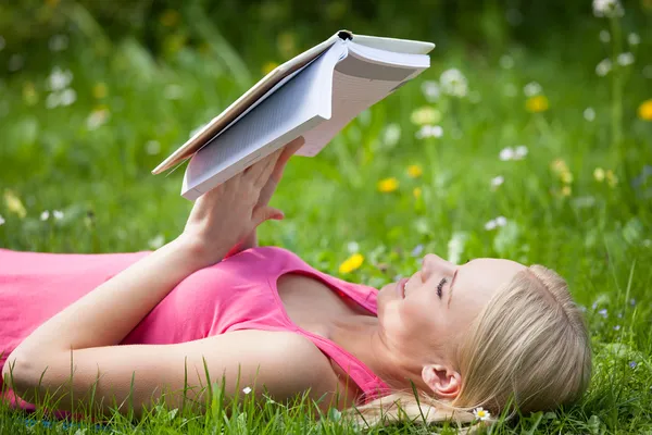 Młoda kobieta w parku czytanie książki — Zdjęcie stockowe