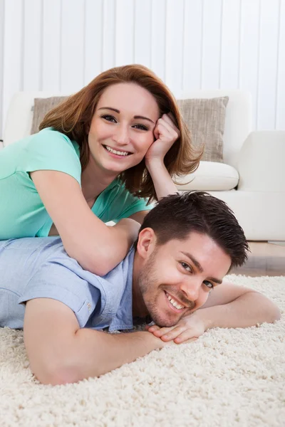 Feliz joven pareja acostada en frente — Foto de Stock