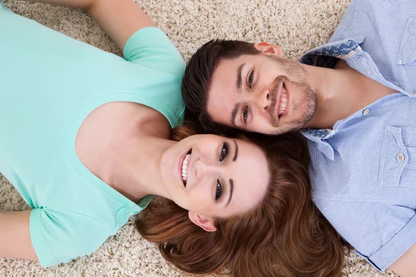 Feliz jovem casal deitado de costas — Fotografia de Stock