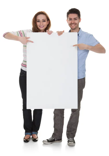 Casal jovem segurando Placard em branco — Fotografia de Stock